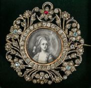 A small 19th century hand painted miniature Set in a pierced floral paste set silver brooch/pendant.