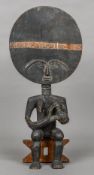 An African tribal moon face figure Of typical form, the woman breast feeding a child. 55 cm high.