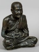 A Chinese bronze figure Modelled as a sage, seated cross legged. 28.5 cm high.