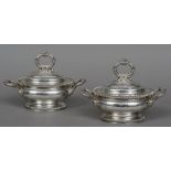 A pair of silver plated twin handled tureens and covers Each with gadrooned rim and scroll handle,