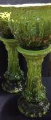 A pair of Soudan ware green glaze majolica jardinieres on stands Each with foliate and scroll