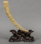 A 19th century Cantonese carved ivory tusk Decorated in the round with figures in various pursuits