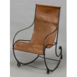 A 19th century wrought iron rocking chair Of scrolling form, fitted with a loose tan leather seat.