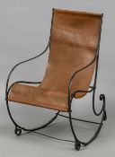 A 19th century wrought iron rocking chair Of scrolling form, fitted with a loose tan leather seat.