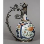 A 19th century unmarked white metal mounted Imari ewer With a floral scroll cast loop handle and