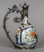 A 19th century unmarked white metal mounted Imari ewer With a floral scroll cast loop handle and