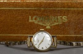 A 9 ct gold ladies Longines wristwatch The white dial with Arabic numerals and batons. 2.5 cm wide.