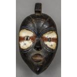 An African tribal infant mask With painted decoration and pursed lips. 20 cm high.