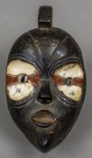 An African tribal infant mask With painted decoration and pursed lips. 20 cm high.