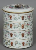 Four Chinese porcelain stacking boxes and cover The cover decorated with figures in a garden,