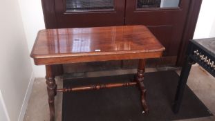 A Victorian walnut centre table The rounded rectangular top supported on turned uprights united