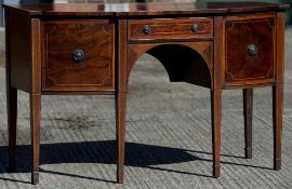 A George III mahogany sideboard The crossbanded and line inlaid shaped top above a central drawer