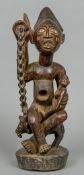 A large carved wooden tribal group Formed as a glass eyed figure holding a child and seated atop a