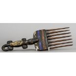 An African tribal comb The handle formed as a crocodile, with painted decoration. 32 cm long.