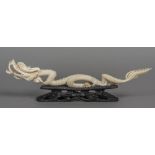 An early 20th century Chinese carved ivory model of a dragon Modelled in full flow holding a pearl,