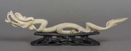 An early 20th century Chinese carved ivory model of a dragon Modelled in full flow holding a pearl,