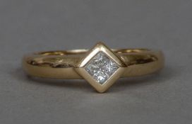 A 9 ct gold diamond ring Set with four princess cut diamonds.