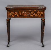 A late 18th/early 19th century Dutch marquetry card table The shaped hinged rectangular top inlaid