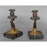 A pair of Regency gilt bronze candlesticks Each formed as scrolling dolphin,