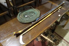 A vintage brass mounted bamboo reed cutter together with a wading stick and a live bait net