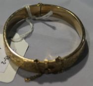 A 9 ct gold bangle with safety chain