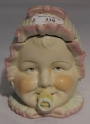 A porcelain box formed as a babys' head