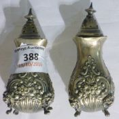 A pair of embossed silver salt and pepper pots