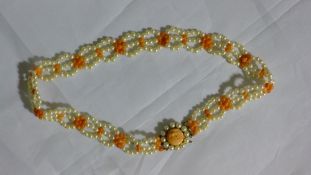A three row pearl and coral necklace with a 9ct gold clasp