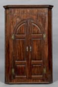 A George III mahogany corner cupboard The moulded cornice above the twin arched panelled doors