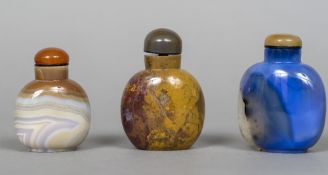 Three Chinese hardstone snuff bottles and stoppers The largest 8 cm high.