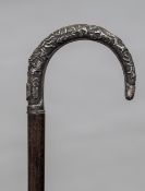 A late 19th century Chinese unmarked white metal handled walking cane The handle decorated with a