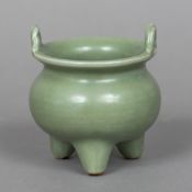 A Chinese porcelain twin handled censor With allover celadon glaze. 10.5 cm high overall.
