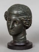 A patinated bronze bust Modelled as a classical figure, mounted on a stepped wooden display plinth.