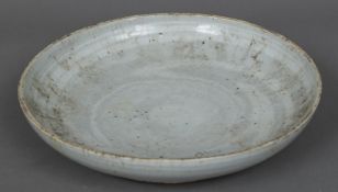 A Chinese porcelain dished plate With allover white glaze,