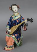 A Chinese porcelain figure Modelled as a young lady playing a pipa,