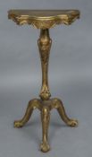 A 19th century carved giltwood torchere The serpentine shaped top above the cabriole column with