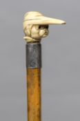 A Victorian ivory handled walking stick The handle formed as a dog wearing a nightcap. 88.