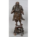 A Chinese root carving Modelled as a bearded sage, mounted on a stand. 65 cm high.