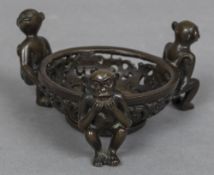 A Chinese bronze stand The pierced dish supported by three monkeys,