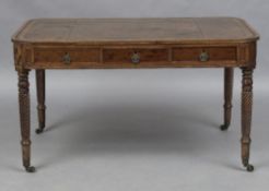 A William IV mahogany library table The gilt tooled green leather inset rounded rectangular top