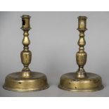 A pair of 18th century brass candlesticks Each with turned stem and domed spreading foot.