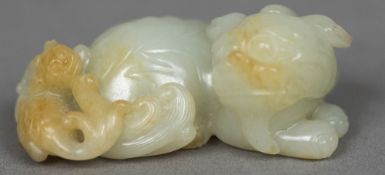A Chinese carved pale and russet jade group Worked as a recumbent temple lion. 6.5 cm wide.