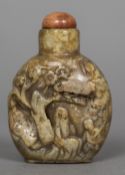 A Chinese carved russet jade snuff bottle and stopper Carved with figures beneath a tree,