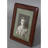 A leather framed photograph frame Worked as crocodile skin, with easel support. 22 x 27.5 cm.