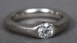 A diamond gypsy set platinum solitaire ring The stone approximately 0.5 carats.