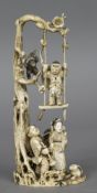 A Japanese carved ivory and inlaid okimono Worked with figures at the foot of a tree,