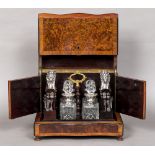 A 19th century French brass inlaid amboyna decanter box Of serpentine form with removable fitted