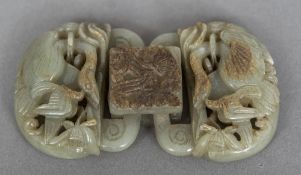 A Chinese carved and pierced russet and celadon glazed belt buckle Worked with birds. 9.5 cm wide.