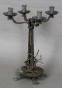 An Arts & Crafts wrought metal candelabra With four branches above the four section column,