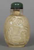 A Chinese carved rock crystal snuff bottle with jade lid Decorated with sagely figures in a garden.
